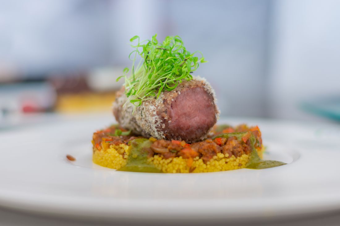 Médaillon d'agneau rosé sur lit de couscous épicé et pousses fraîches