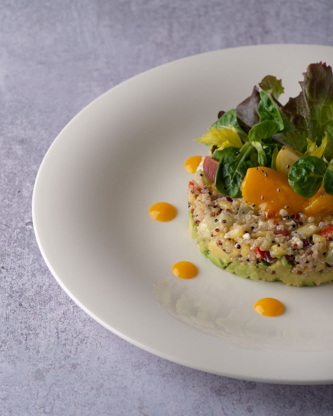 Salade gastronomique de quinoa, avocat et mangue, jeunes pousses — entrée traiteur végétarienne